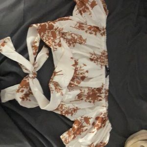 White and brown cropped top with off the sleeve shoulders and floral design